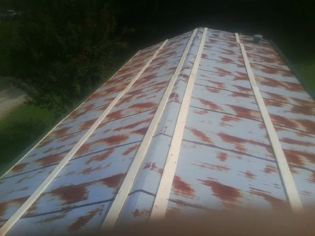 Rusted metal roof panels with new wood purlins before replacement — Storm Damage Roof Repair in Wilson Creek by Roofing Brothers